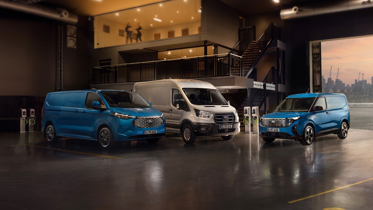 Drei elektrische Ford-Nutzfahrzeuge in einer Ladehalle mit Ladestationen im Hintergrund. Drei elektrische Ford-Nutzfahrzeuge in einer Ladehalle mit Ladestationen im Hintergrund.