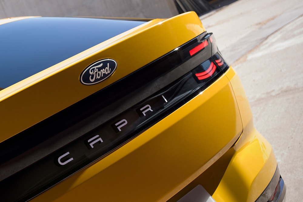 Eine Nahansicht des CAPRI-Schriftzugs auf der Rückseite des neuen gelben vollelektrischen Ford Capri® SUV. 