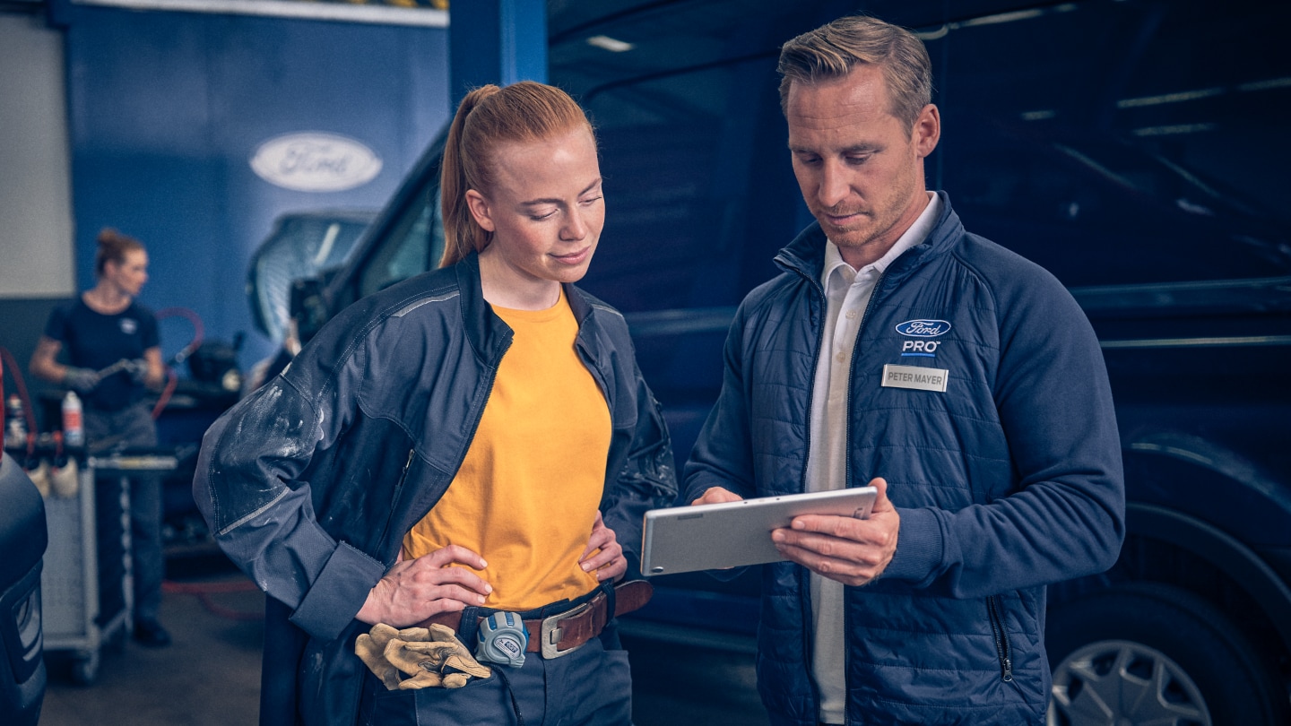 Service person and a Ford E-Transit owner discussing paperwork