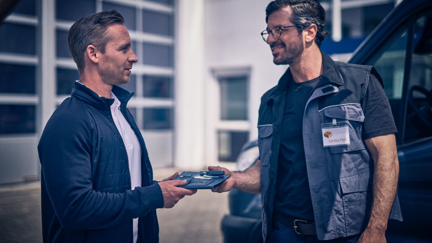 A customer and an advisor exchanging keys and paperwork