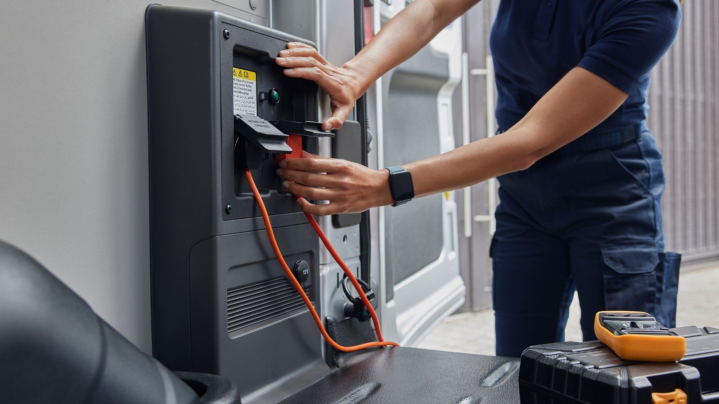 Arbeiter nutzt Ford Pro Power Onboard elektrischen Ford E-Transit Kastenwagen Innenraum