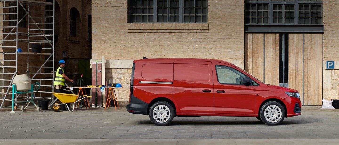 Ford Transit Connect in Maple Red mit seitlicher Beladetür auf einer Baustelle.