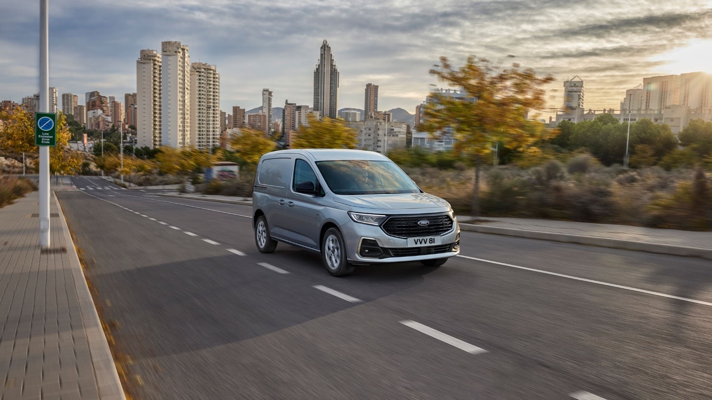 Ford Transit Connect in Stardust Silver fährt auf einer Straße.