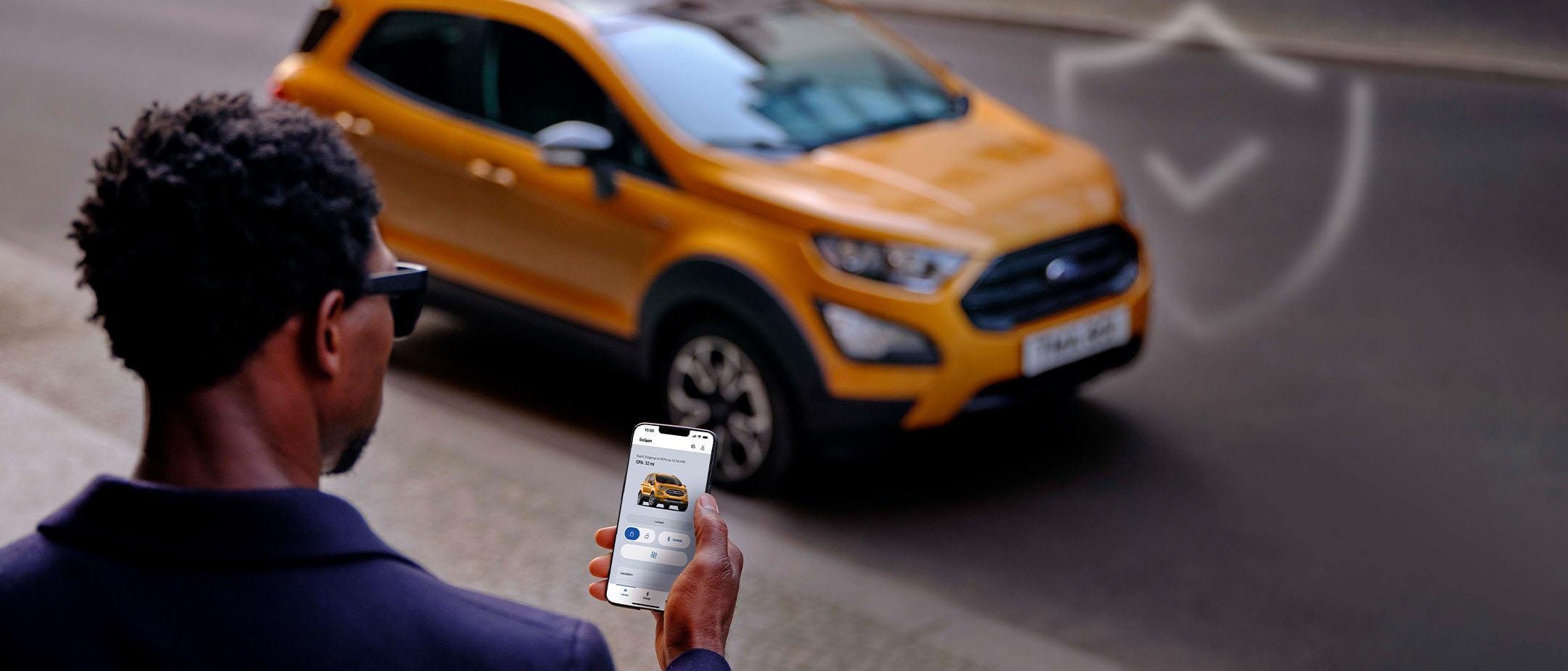 Mann mit Smartphone nutzt mobile App neben Ford EcoSport